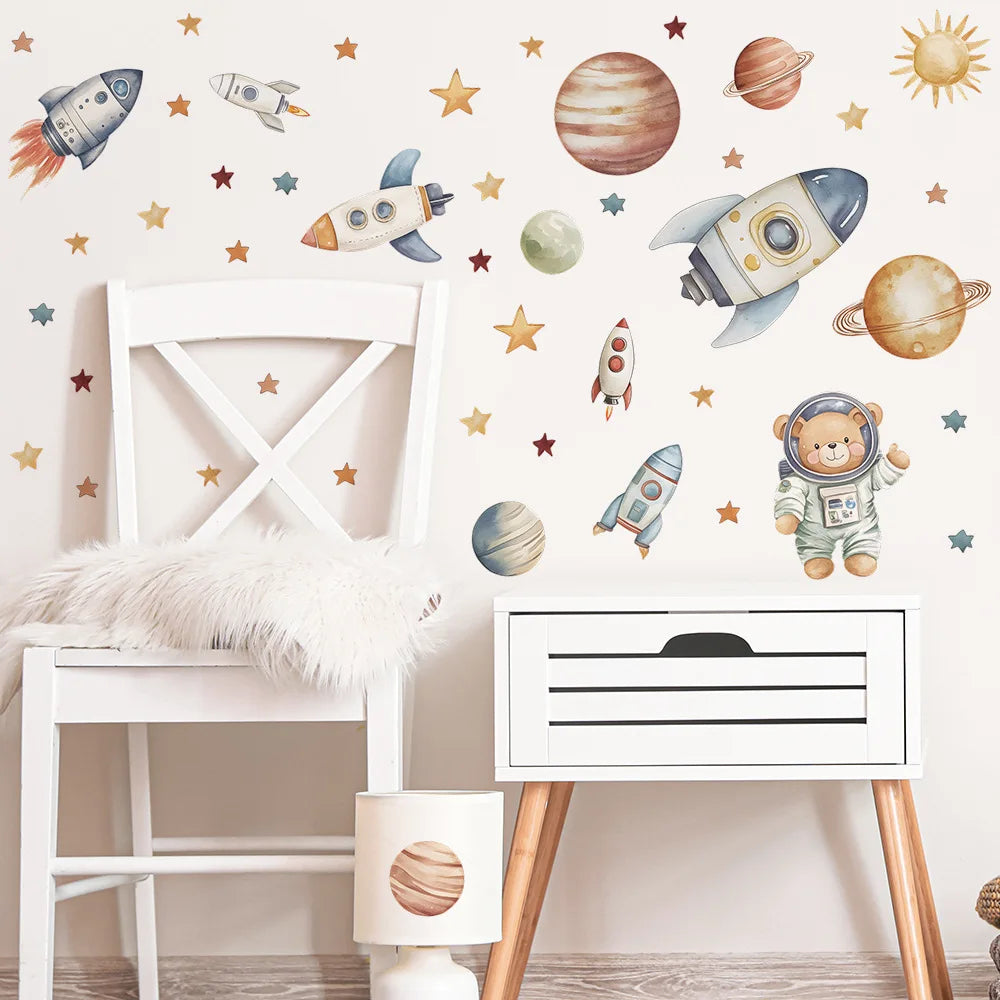Wall stickers featuring various space and airplane designs, including rockets, planets, and a teddy bear pilot, decorating a 