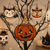 A set of vintage wooden Halloween hanging ornaments featuring carved pumpkins and cats on dark branches.