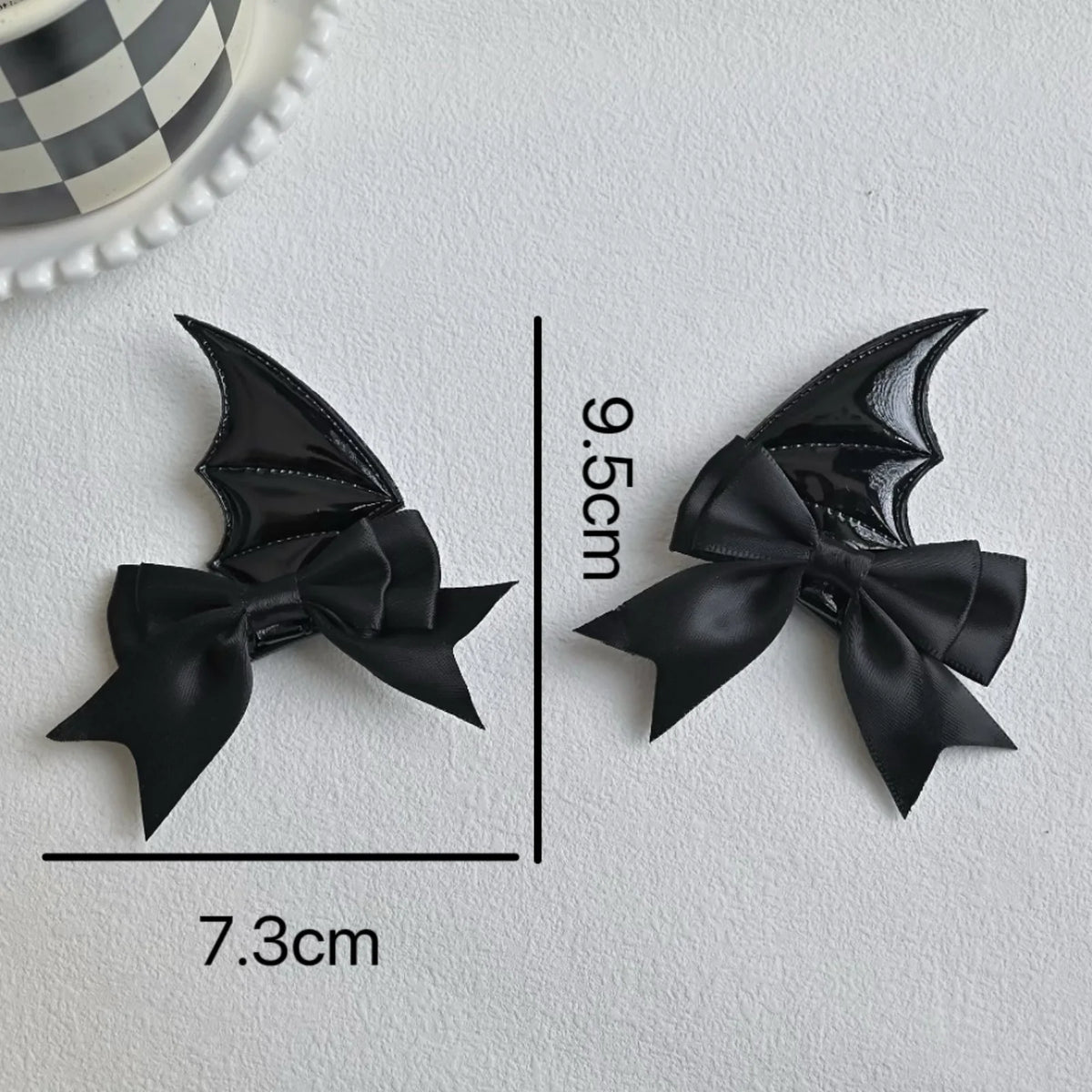 A set of black devil horn and bat wing hair clips, measuring 9.5cm long.