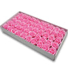 A rectangular box filled with pink artificial rose flower heads for DIY crafts and decor