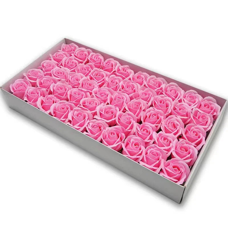 A rectangular box filled with pink artificial rose flower heads for DIY crafts and decor