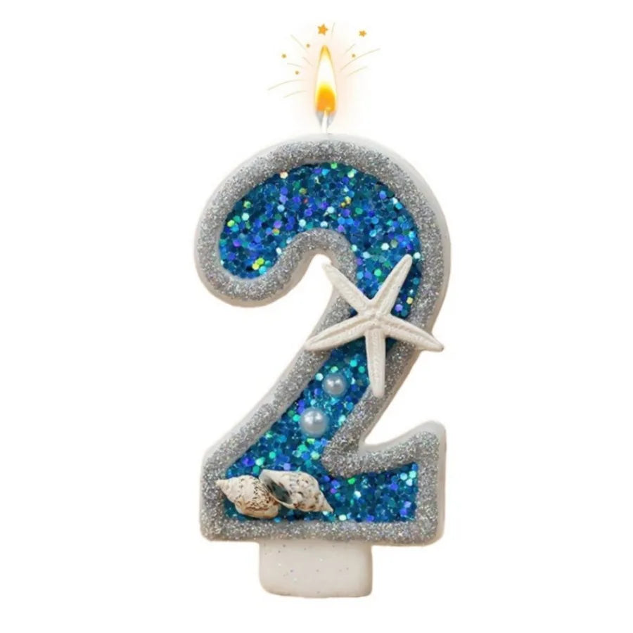 A silver glitter candle shaped like the number 2 with blue sparkling glitter and a flame on top.