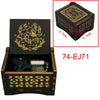 A wooden music box with intricate gold-colored patterns and a lid showing an animal design.
