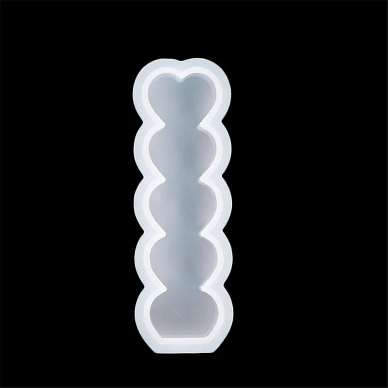 A white silicone candle mold kit with a heart-shaped design, shown against a black background.