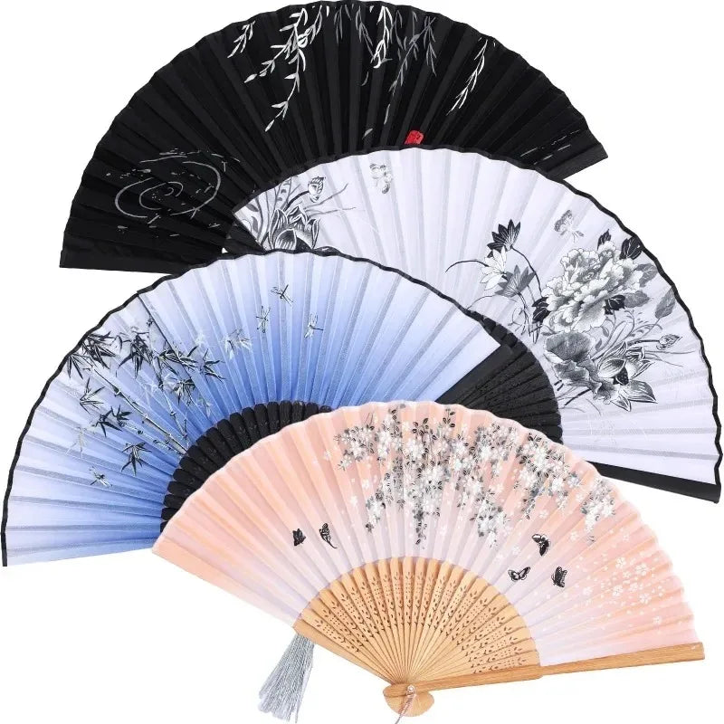 A collection of vintage bamboo folding hand fans in black, white, and pink tones.