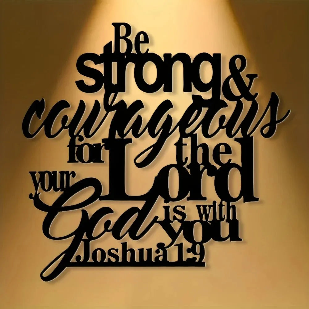 Black script text on a light brown wall featuring the Bible verse Be strong & courageous for the Lord God is with you Joshua 