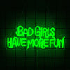 A neon green sign hangs against a dark grid background with the text BAD GIRLS HAVE MORE FUN.