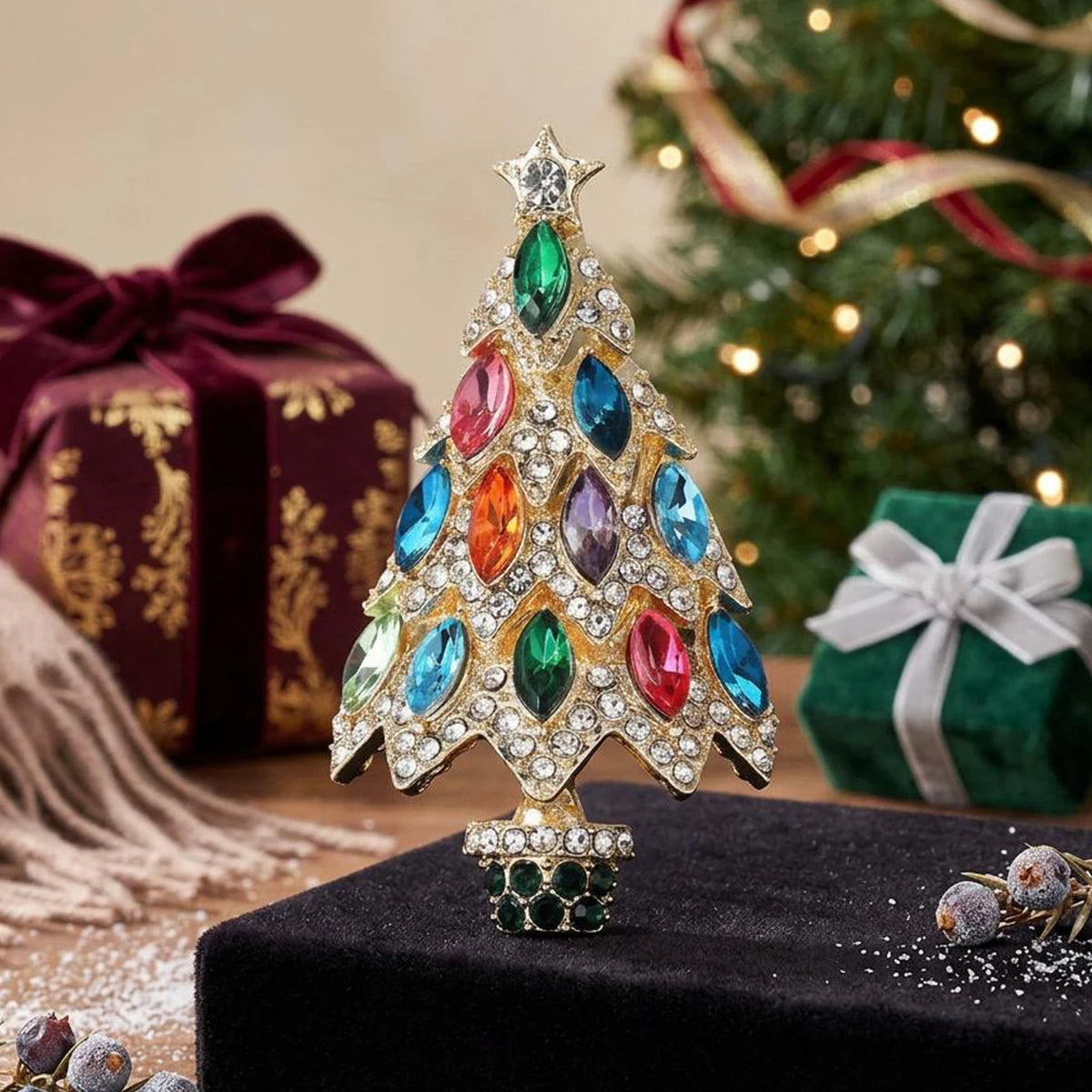 A sparkling rhinestone Christmas tree brooch pin with colorful gemstone leaves displayed on a black velvet surface.