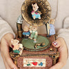 A hand holds a vintage carousel music box decoration featuring a wooden top with a small animal figure and a large, decorativ