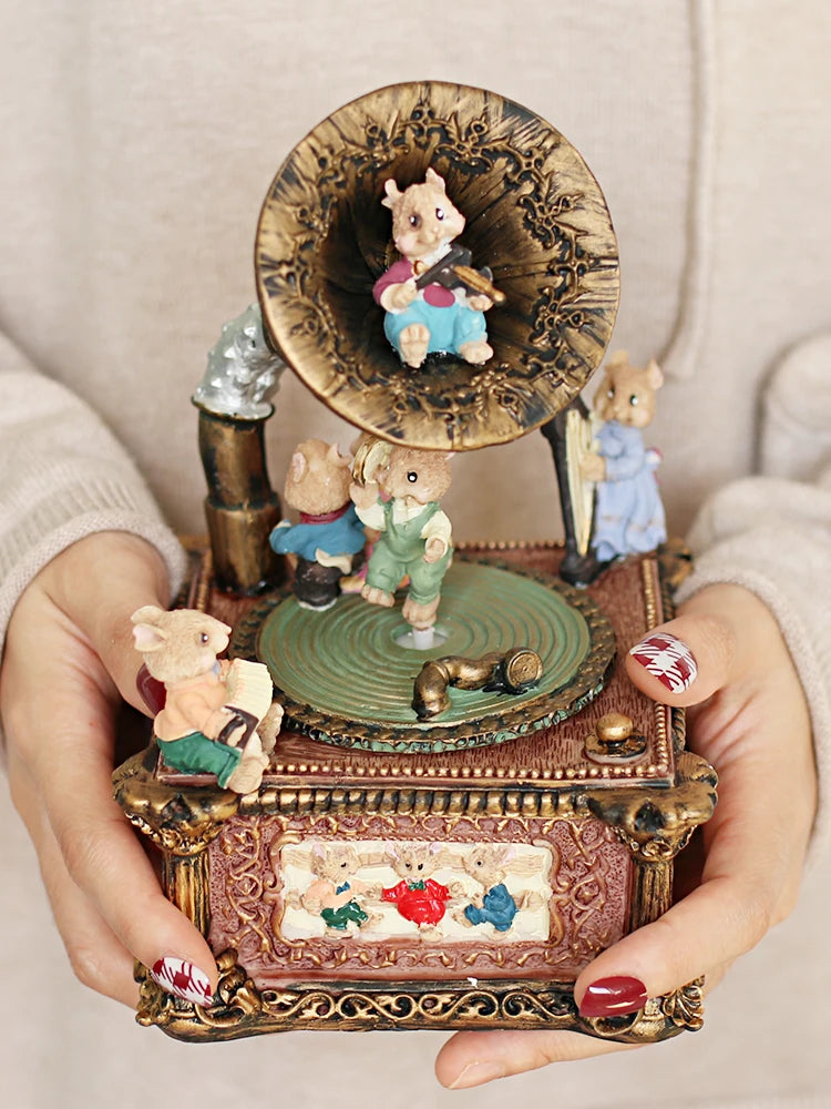 A hand holds a vintage carousel music box decoration featuring a wooden top with a small animal figure and a large, decorativ