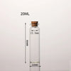 A clear glass bottle with a cork stopper and measurement markings, labeled 20ML.