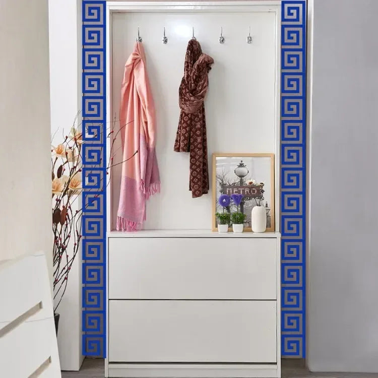 A white cabinet with blue decorative trim displays several draped scarves and a framed picture.