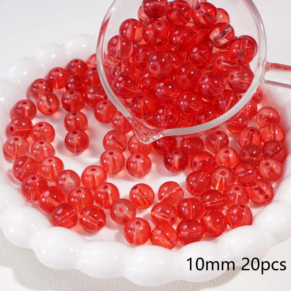 A clear glass container filled with small, round, translucent red beads for jewelry making