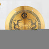 A round brass Feng Shui Zen table gong featuring dragon and Taiji symbols engraved on its surface.