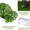 Artificial bonsai tree decoration with green leaves and four legs standing on a table.