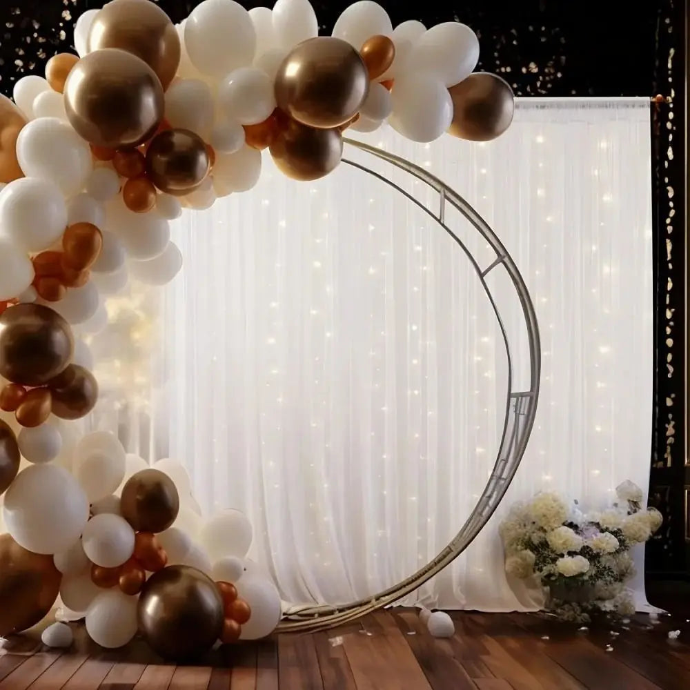 Elegant white wedding tulle backdrop decorated with gold and bronze balloons and string lights