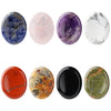 A collection of five oval natural stone beads in shades of blue, pink, purple, white, and black.