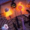 Un ensemble de lanternes à bâton lumineuses d'Halloween avec des motifs de citrouille et de fantôme sur une surface en maille