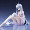 A figurine of an anime girl with long blue hair in a light purple dress sitting pose.