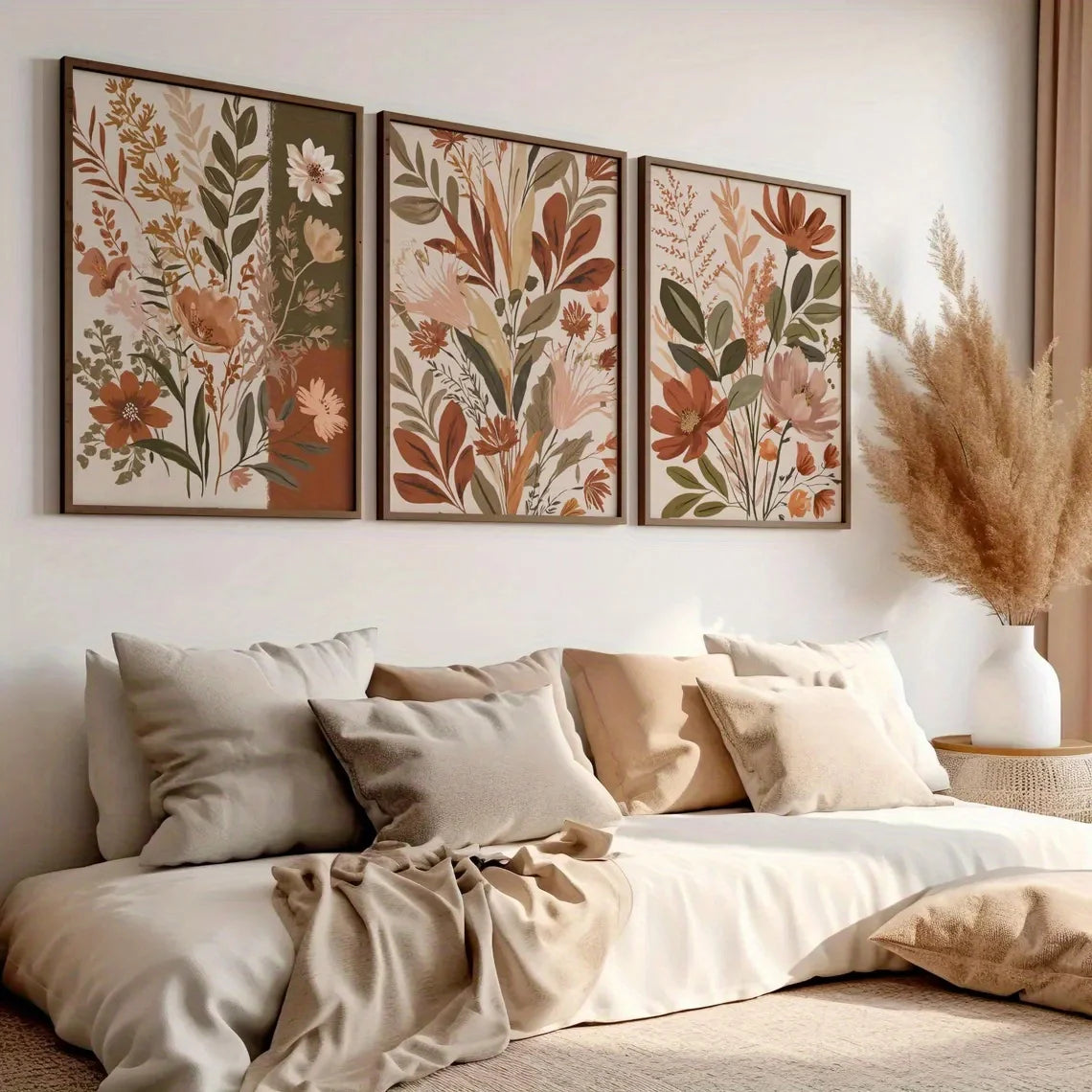 A set of three canvas art prints featuring sage green and earthy floral designs displayed on a white wall.