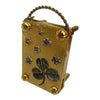 A small brass metal flower press kit with a wire loop handle and decorative pressed flowers.