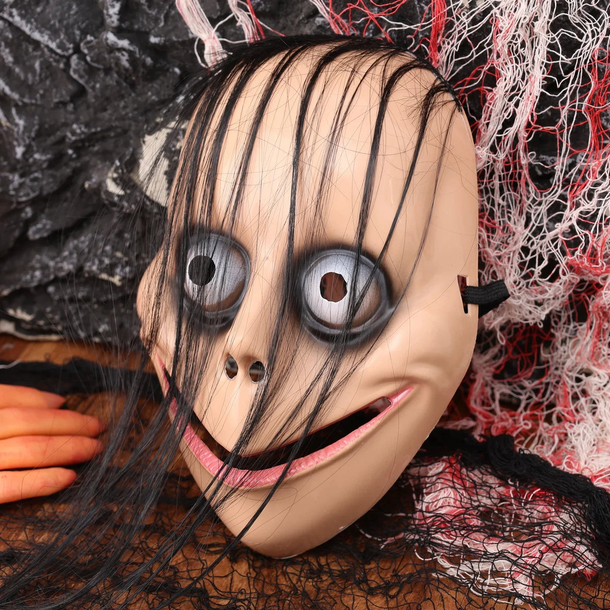 A full face horror costume mask resembling a creepy evil clown with pale skin and exaggerated features.
