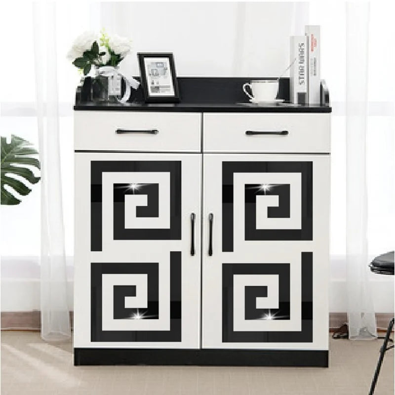 A white cabinet with black accents and glass doors displaying various home decor items.