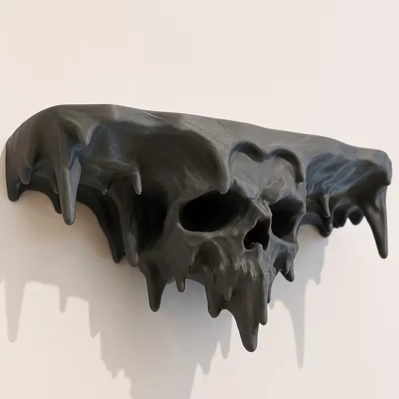 A black, melted skull wall shelf with dripping details, displayed against a white background.