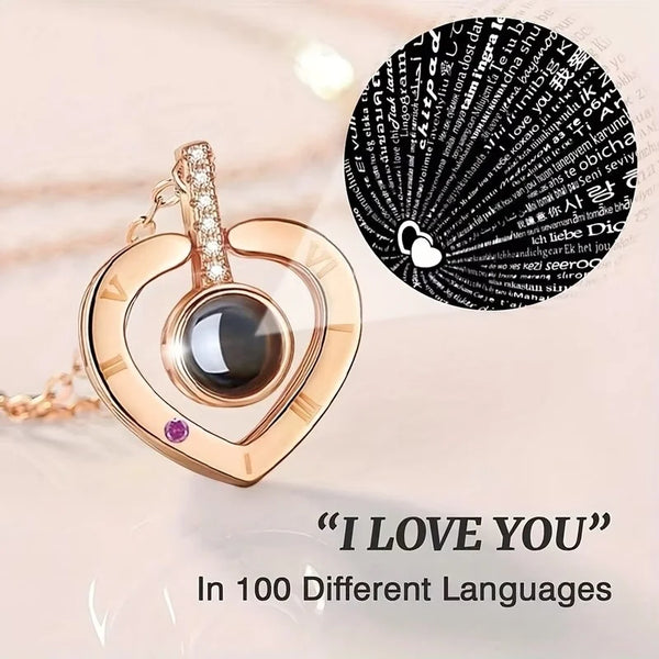 A gold-toned necklace featuring a heart pendant with a dark stone and a diamond charm, set against a background of text in va