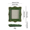 A vintage baroque green resin picture frame with ornate detailing and a clear glass insert.