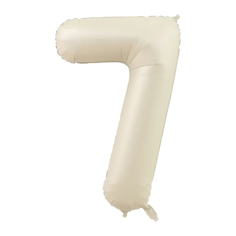 A beige foil number balloon shaped like the numeral 7.