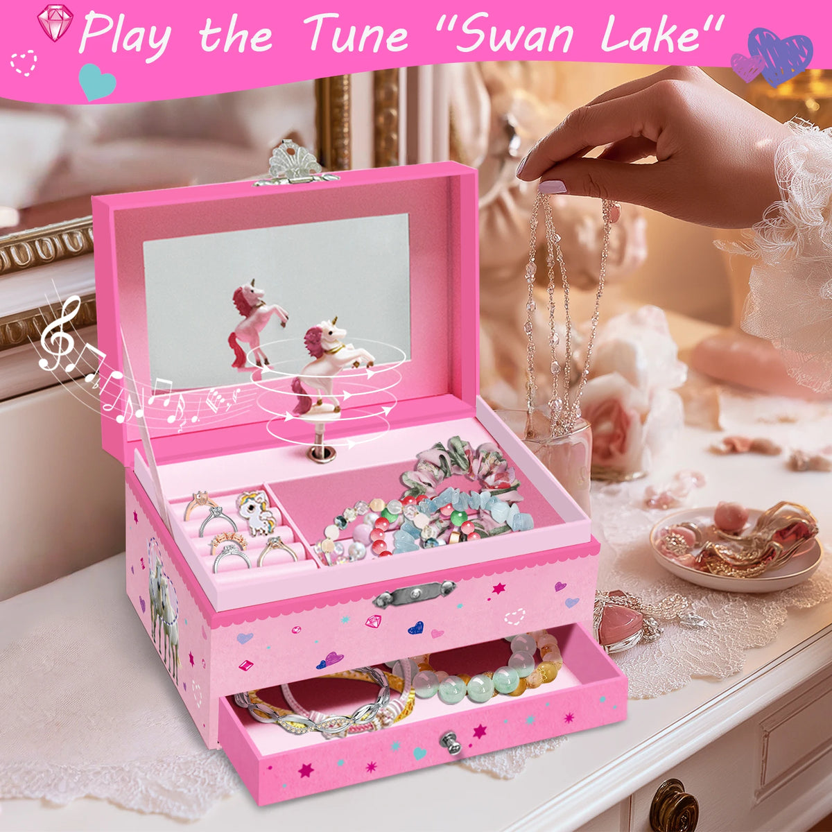A pink jewelry box with a rotating unicorn dancer and various musical accessories is displayed on a white surface.