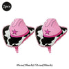 A pair of pink and black cow print foil horse number balloons with pink ears and tails.