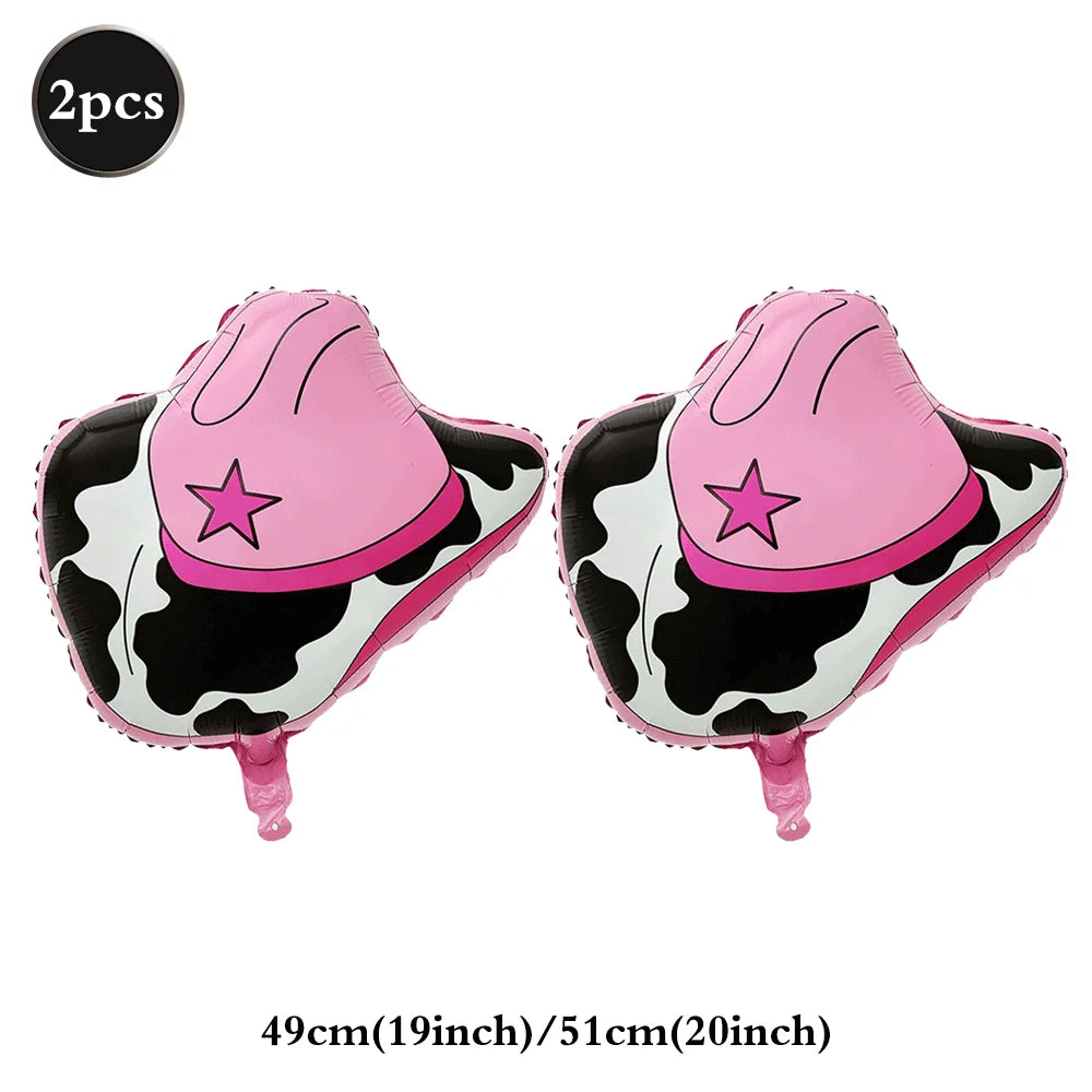 A pair of pink and black cow print foil horse number balloons with pink ears and tails.