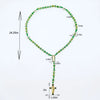 A green crystal rosary necklace featuring a Saint Jude and Virgin Mary cross pendant.