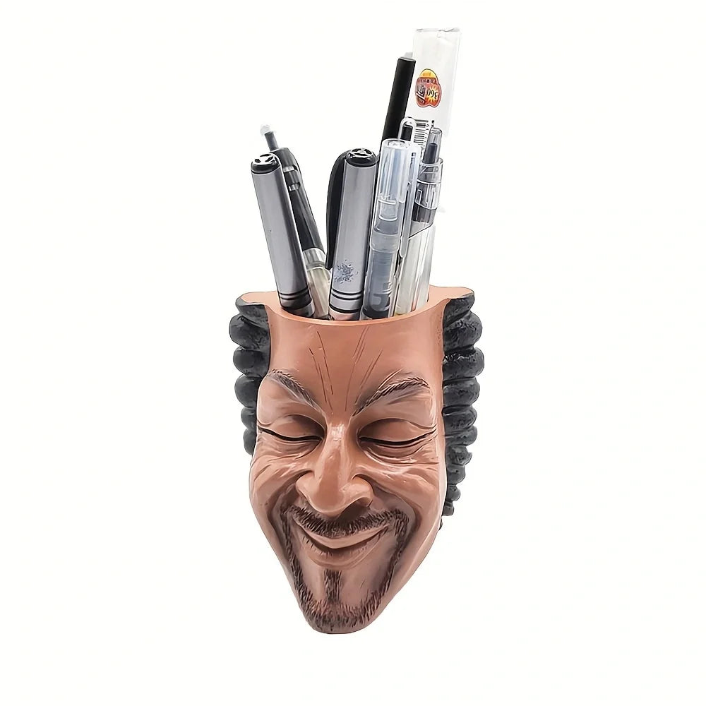 A terracotta artistic face planter holding several thin glass tubes or tools.