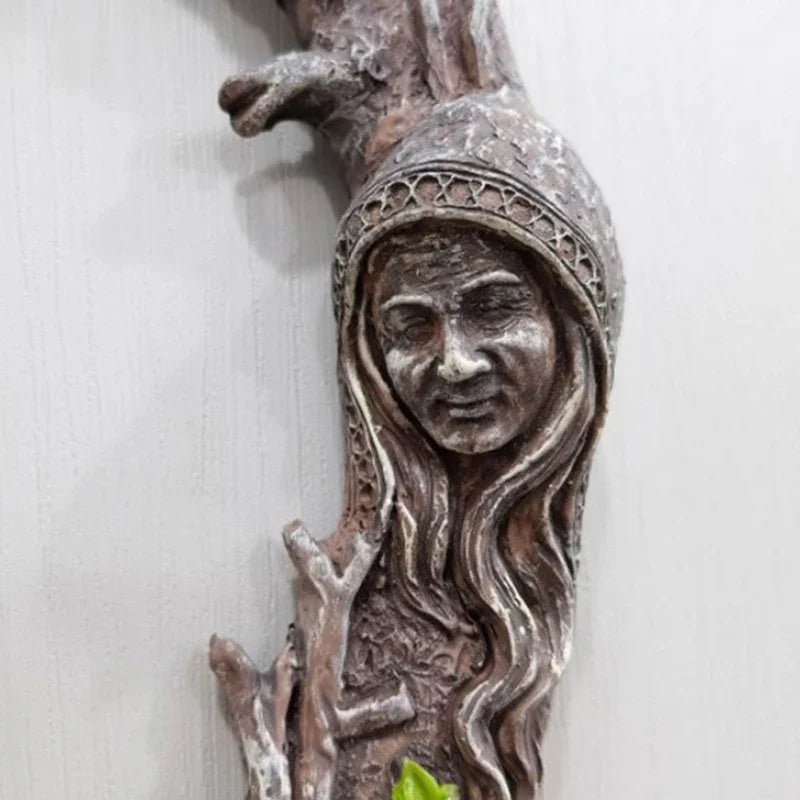 A rustic wall hanging mirror featuring a face and pentagram amulet carved in weathered wood.