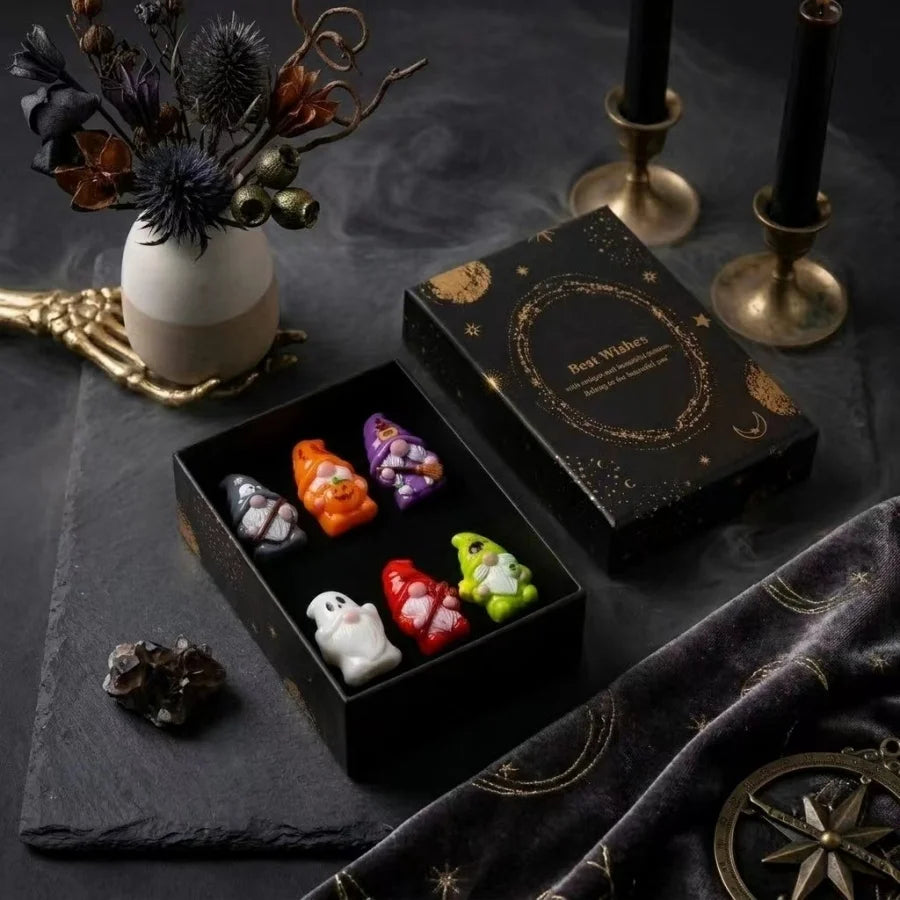 A collection of Halloween witch mini dwarf resin figurines in various colors displayed on a dark surface.