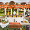 Artificial maple leaf garland hanging vine displayed on a wooden shelf with various decorative items.
