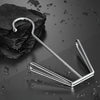 A stainless steel hanging shoe organizer with a double hook resting on a dark surface.