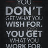 A motivational quote print on a dark background that reads You don't get what you wish for you get what you work for.