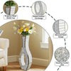 Tall silver mirrored vase with a crushed diamond finish displayed on a wooden floor.