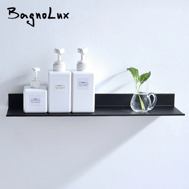 Modern matte black wall shelf displaying three white soap dispensers and a small green plant.