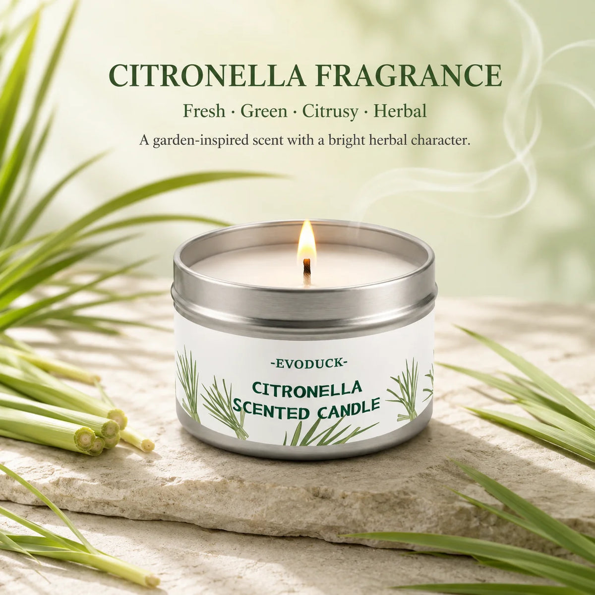 A jar of Citronella scented candle with a lit wick resting on a light-colored stone surrounded by green lemongrass stalks.
