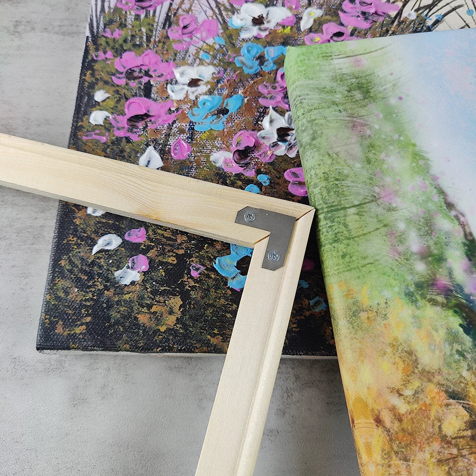 A wooden easel holds a canvas art poster featuring vibrant floral and abstract colors.