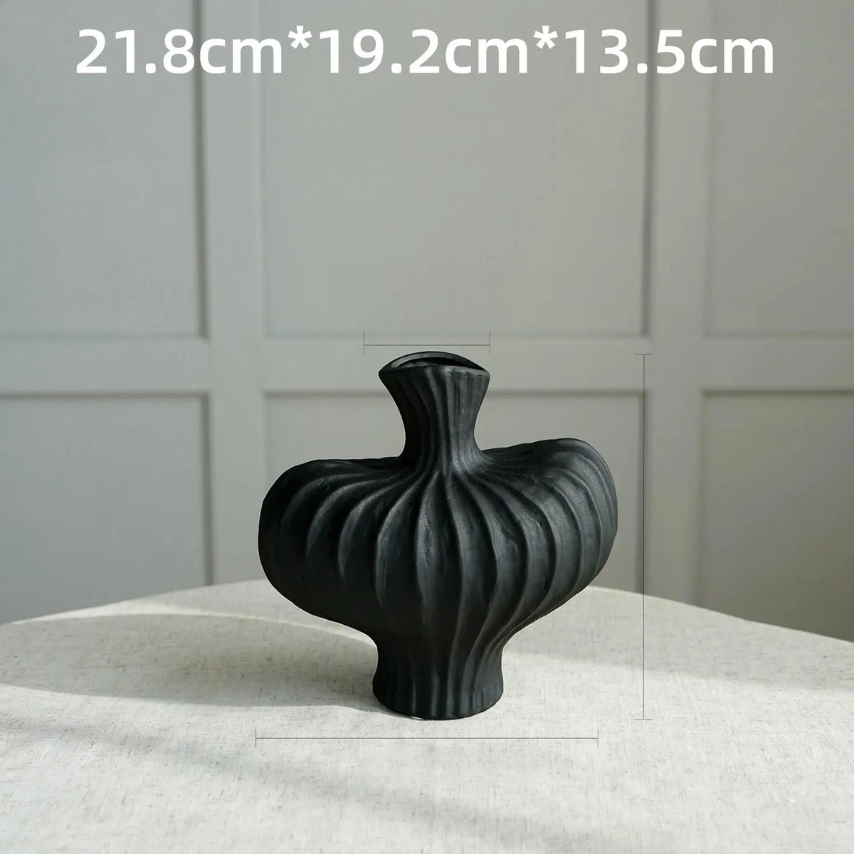 A black, textured Nordic modern vase is shown on a white surface.