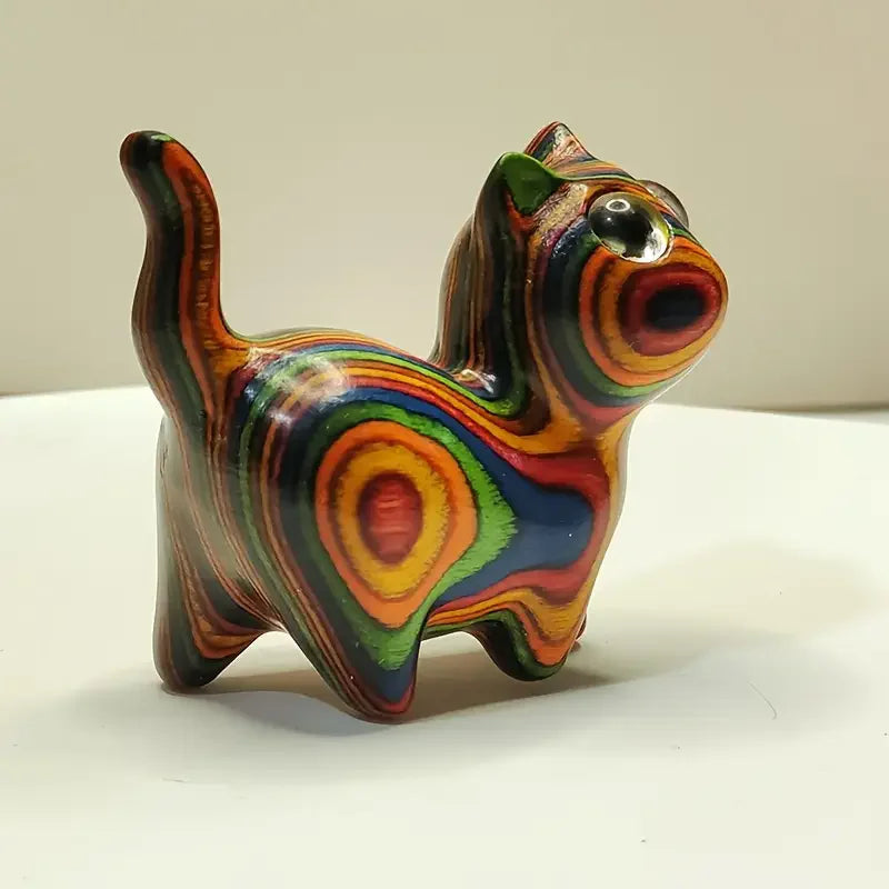 Hand-painted wooden sculpture of a kitten with vibrant, swirling colors.