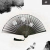 A black and white photograph of a vintage silk bamboo folding hand fan with delicate floral designs.