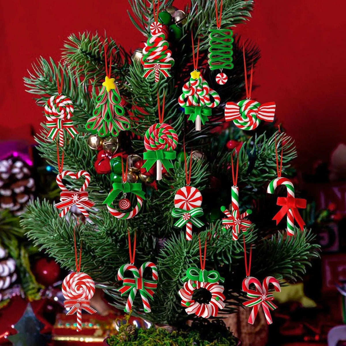 A festive arrangement of mini wooden candy cane Christmas ornaments in red, white, and green on a green pine branch.
