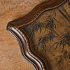 A vintage resin photo frame with a dark brown, distressed finish and a decorative, scalloped edge, set on a wooden surface.
